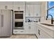 Kitchen featuring stainless steel appliances, white cabinets, and a sink under a window at 17300 Pesce Loop, Montverde, FL 34756