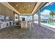 Beautiful outdoor kitchen and bar area overlooking a sparkling pool with stunning waterfront views at 17300 Pesce Loop, Montverde, FL 34756