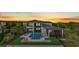 Aerial view of a backyard with a pool, fenced yard with artificial turf, and outdoor living space at sunset at 17300 Pesce Loop, Montverde, FL 34756