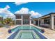 Beautiful rear view of the home featuring a pool, spa, outdoor kitchen, and lounge area at 17300 Pesce Loop, Montverde, FL 34756
