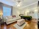 Bedroom with large window, couch, ceiling fan, hardwood floors and view into sleeping area at 2107 University Dr, Orlando, FL 32804