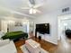 Bedroom featuring hardwood floors, TV, ceiling fan, decorative ottoman, and view into living area at 2107 University Dr, Orlando, FL 32804