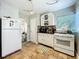 Bright kitchen featuring white cabinets and appliances, and vintage tile flooring with a view to the dining area at 2107 University Dr, Orlando, FL 32804
