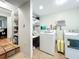 Functional laundry room with washer, dryer, open shelving, and adjacent pantry storage at 2107 University Dr, Orlando, FL 32804