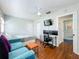 Cozy living room featuring hardwood floors, modern furniture, and a comfortable workspace with dual monitors at 2107 University Dr, Orlando, FL 32804