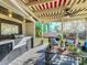 Inviting covered patio with an outdoor kitchen, comfortable seating, and lush landscaping at 2107 University Dr, Orlando, FL 32804