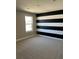 Bedroom showcasing striped accent wall, neutral carpet and a window at 2313 Ivy Harvest Pl, Oviedo, FL 32765