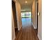Hallway with wood-look flooring, leading to an open living area with lots of natural light at 2313 Ivy Harvest Pl, Oviedo, FL 32765