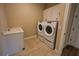 This home's laundry room features modern washer and dryer units, sink and white storage cabinets at 2313 Ivy Harvest Pl, Oviedo, FL 32765