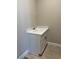 Utility sink with white cabinet and countertop, featuring neutral tile flooring at 2313 Ivy Harvest Pl, Oviedo, FL 32765