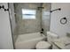 Updated bathroom features a tub with gray tiling and black fixtures at 2360 Justy Way, Orlando, FL 32817
