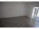 Bright bedroom with wood-look tile flooring and sliding glass door to the patio at 2360 Justy Way, Orlando, FL 32817