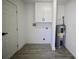 Clean, well-lit laundry area with new water heater and modern cabinetry for storage at 2360 Justy Way, Orlando, FL 32817