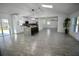 Bright open-concept living space features a kitchen with an island and white tile flooring at 2360 Justy Way, Orlando, FL 32817