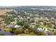 An aerial view captures a residential neighborhood with mature trees and glimpses of a tranquil lake at 2365 Eagle Trace Dr, Kissimmee, FL 34746