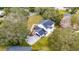 Aerial view of a home with solar panels and a driveway that are framed by mature trees and green lawn at 2365 Eagle Trace Dr, Kissimmee, FL 34746