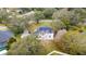 A bird's-eye view of a home with solar panels, surrounded by mature trees and lush landscaping at 2365 Eagle Trace Dr, Kissimmee, FL 34746