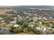 An aerial shot focuses on a neighborhood home surrounded by mature trees and lush greenery at 2365 Eagle Trace Dr, Kissimmee, FL 34746
