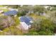 An aerial view shows a home with solar panels, set on a large lot with mature trees and beautiful landscaping at 2365 Eagle Trace Dr, Kissimmee, FL 34746