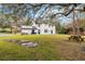 Backyard view of a two-story home featuring solar panels, a lush lawn, and a picnic table at 2365 Eagle Trace Dr, Kissimmee, FL 34746
