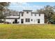 Spacious backyard view highlighting the two-story home with solar panels, lawn, and backyard play equipment at 2365 Eagle Trace Dr, Kissimmee, FL 34746