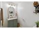 Stylish half-bathroom featuring a green vanity, gold fixtures, decorative mirror, and modern patterned tile flooring at 2365 Eagle Trace Dr, Kissimmee, FL 34746