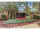 The Eagle Trace community sign features brick pillars, lush greenery, and vibrant red flowers at 2365 Eagle Trace Dr, Kissimmee, FL 34746