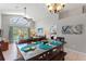 Bright dining area features modern chandelier, slider views of outdoor living, and decorative wall art at 248 Rosso Dr, Davenport, FL 33837