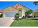 Charming yellow single-Gathering home featuring a red tile roof and manicured front lawn at 248 Rosso Dr, Davenport, FL 33837