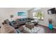 Cozy living room featuring a large sectional sofa, a bright window, and stylish decor at 248 Rosso Dr, Davenport, FL 33837