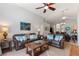 Living room showing two matching leather couches, decorative pillows, fan and access to dining and kitchen at 248 Rosso Dr, Davenport, FL 33837