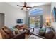 Comfortable living room with vaulted ceilings, fan, and sliding door leading to screened pool at 248 Rosso Dr, Davenport, FL 33837