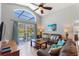 Inviting living room with vaulted ceilings, fan, and sliding door leading to screened pool and patio at 248 Rosso Dr, Davenport, FL 33837