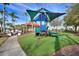 View of a community playground with climbing structure, slide, swings, and green turf at 248 Rosso Dr, Davenport, FL 33837