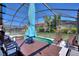 Outdoor pool inside screened enclosure showcasing outdoor dining table and lounge chairs, ideal for entertaining at 248 Rosso Dr, Davenport, FL 33837