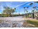 Well-maintained sand volleyball court with covered seating area, surrounded by palm trees and manicured lawns at 248 Rosso Dr, Davenport, FL 33837