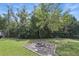 The backyard has a charming fire pit and a surrounding border of greenery and landscaping at 2502 Falkner Rd, Orlando, FL 32810