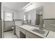 Bathroom with double sinks, tiled floor, shower, and a large mirror with modern lighting at 2502 Falkner Rd, Orlando, FL 32810