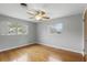 Light-filled bedroom with hardwood floors, a ceiling fan, and ample natural light from two windows at 2502 Falkner Rd, Orlando, FL 32810