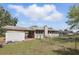 Exterior shot of the home and backyard featuring a storage shed, car port, and chain link fence at 2502 Falkner Rd, Orlando, FL 32810
