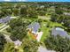 Expansive aerial view showcases a well-manicured property with a large home, lush greenery, and a screened-in pool at 2544 Carter Grove Cir, Windermere, FL 34786