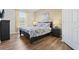 Cozy bedroom with wooden floors, a queen-size bed with decorative pillows, and matching bedside tables with lamps at 2774 Almaton Loop # 403, Kissimmee, FL 34747