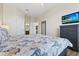 Airy bedroom with a floral patterned queen size bed, a large dresser with a TV, and two entry doors at 2774 Almaton Loop # 403, Kissimmee, FL 34747