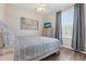 Comfortable bedroom features a large bed with a grey patterned cover, with decorative artwork on the wall at 2774 Almaton Loop # 403, Kissimmee, FL 34747