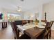 Bright dining room featuring wood table set for six, light floors, sliding door to balcony, and modern decor at 2774 Almaton Loop # 403, Kissimmee, FL 34747