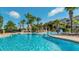 Inviting community pool with crystal-clear water and comfortable lounge chairs, surrounded by palm trees at 2774 Almaton Loop # 403, Kissimmee, FL 34747