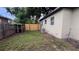 Spacious backyard featuring a wooden fence, lush green grass, and an outdoor air conditioning unit at 3440 S Nashville Ave, Orlando, FL 32839