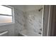 This bathroom features a tiled shower, and white marble style backsplash, and chrome fixtures at 3440 S Nashville Ave, Orlando, FL 32839