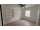 A sunlit bedroom with a built-in shelf and neutral tile floors at 3440 S Nashville Ave, Orlando, FL 32839