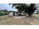 Exterior shot showcasing mature trees, neutral paint and a small front porch at 3440 S Nashville Ave, Orlando, FL 32839